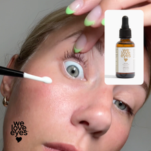 Load image into Gallery viewer, Person applying a product to their eye with 'we love eyes' branding.