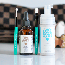 Load image into Gallery viewer, Set of 'we love eyes' skincare products on a reflective surface with a blurred background.