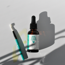 Load image into Gallery viewer, Bottle of 'we love eyes' eye serum with a dropper on a light gray background