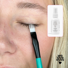 Load image into Gallery viewer, Person applying eyelash serum with a brush, inset with product packaging labeled 'we love eyes'.
