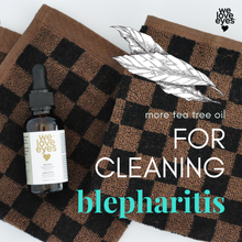 Load image into Gallery viewer, Bottle of 'we love eyes' tea tree oil on checkered fabric with text about using it for blepharitis.
